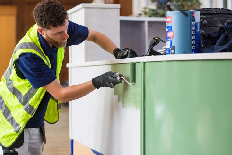 Collab decorator painting a green library counter