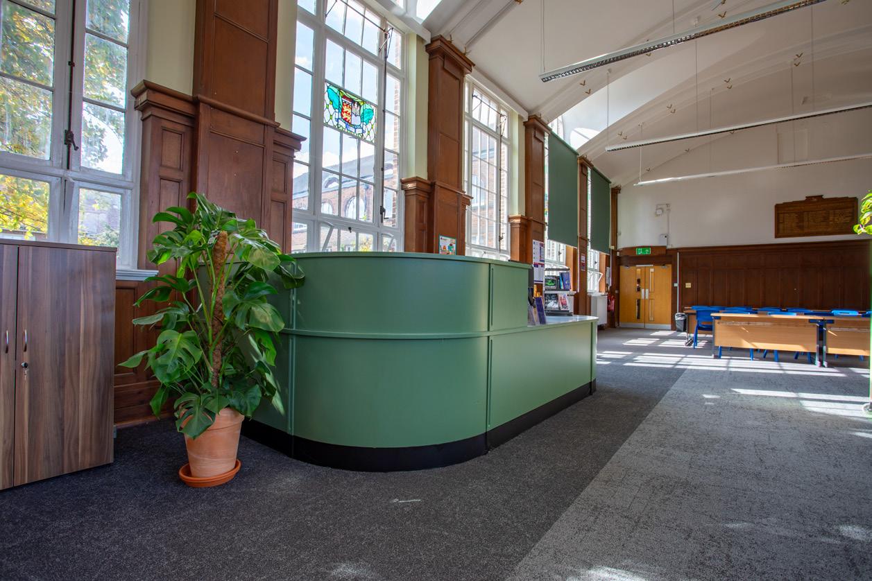 Curved green reception desk in a refurbished interior