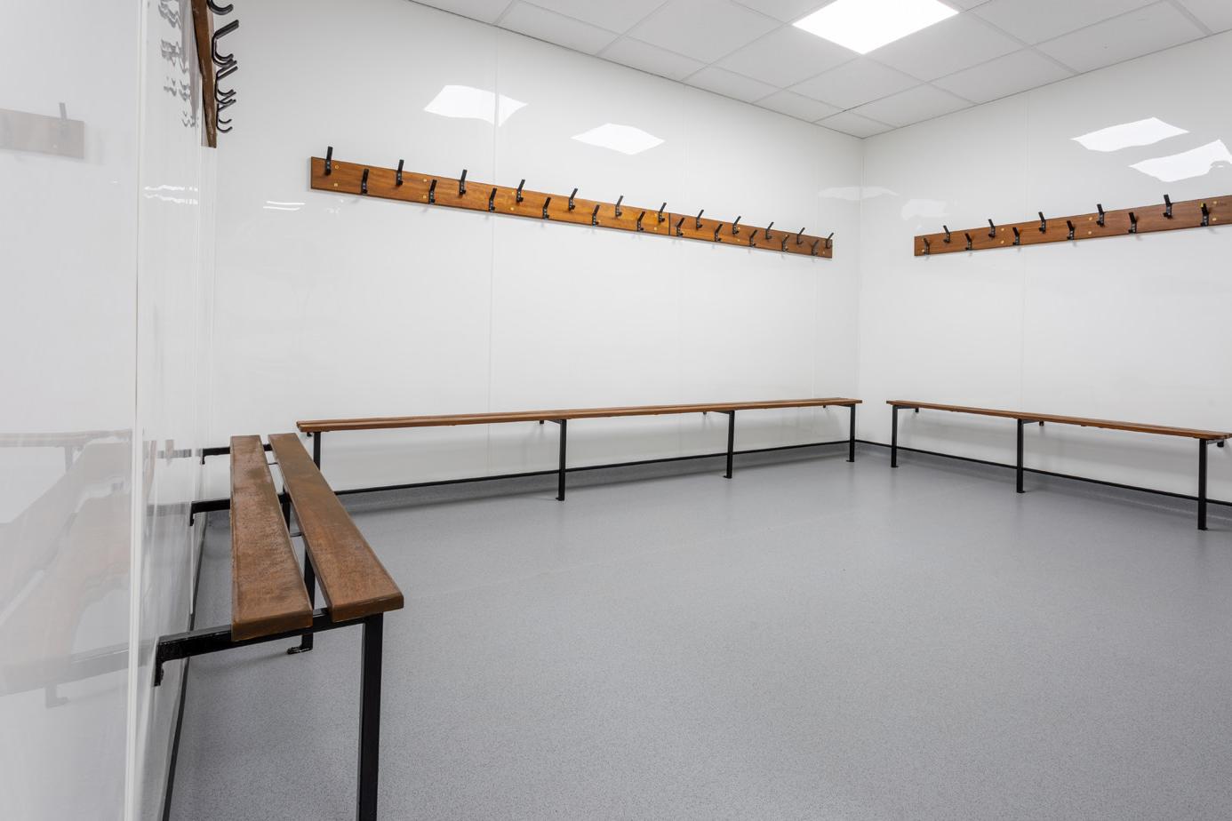 After: refurbished changing room with white hygienic cladding and grey safety flooring